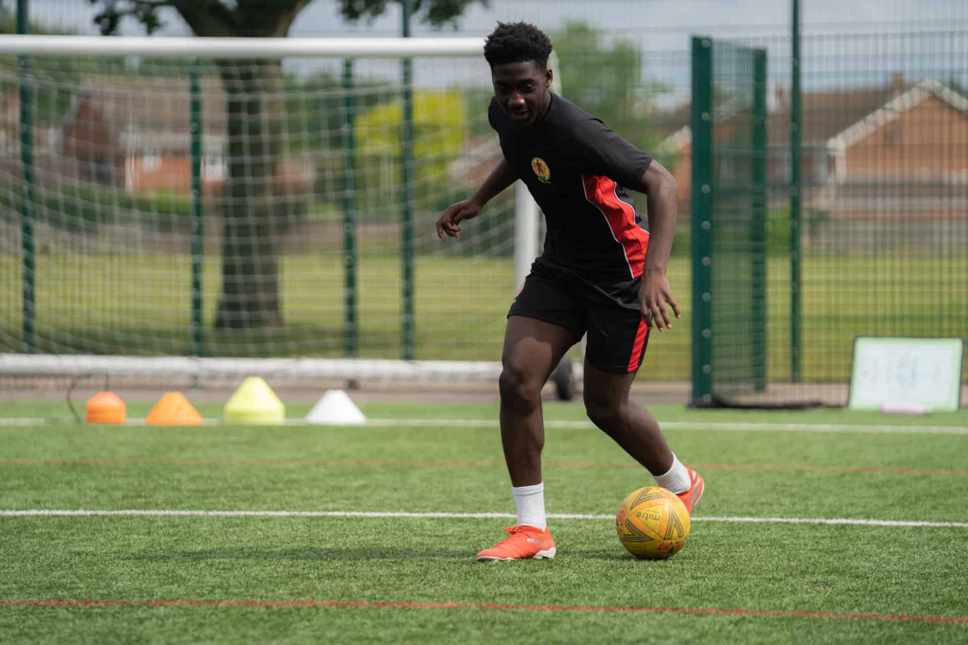 A man engaged in web development kicking a football ball.